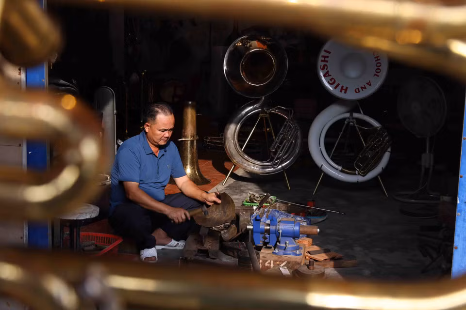 “范炮铜管乐器制作行业的独特之处在于，大部分步骤都是手工完成的。工匠们将铜管轧平，手工焊制管乐器，只使用自制的折弯机和车床来制作乐器上的细节和完成较难的工序。图自越通社