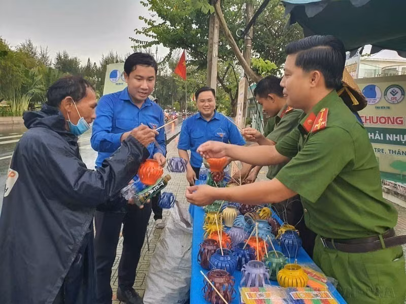 在宣传“垃圾分类保护环境、共建绿色槟椥”活动中，市民将废旧塑料瓶、铝罐和电池带来兑换中秋灯笼。图自越通社