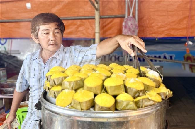 安江传统糕饼艺人正忙于制作刚出锅、香气扑鼻的椰糖发糕,展现地道南部风味。图自越通社