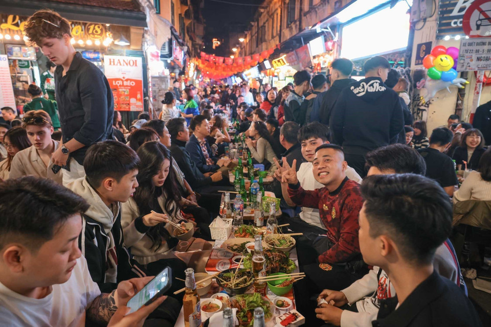 还剑湖周边街道区域迎来许多当地居民及外国游客游玩、品尝美食，共同期待2026新年。图自越通社