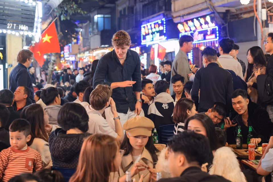 外国游客欣喜地融入河内古街区的新年交替时刻。图自越通社