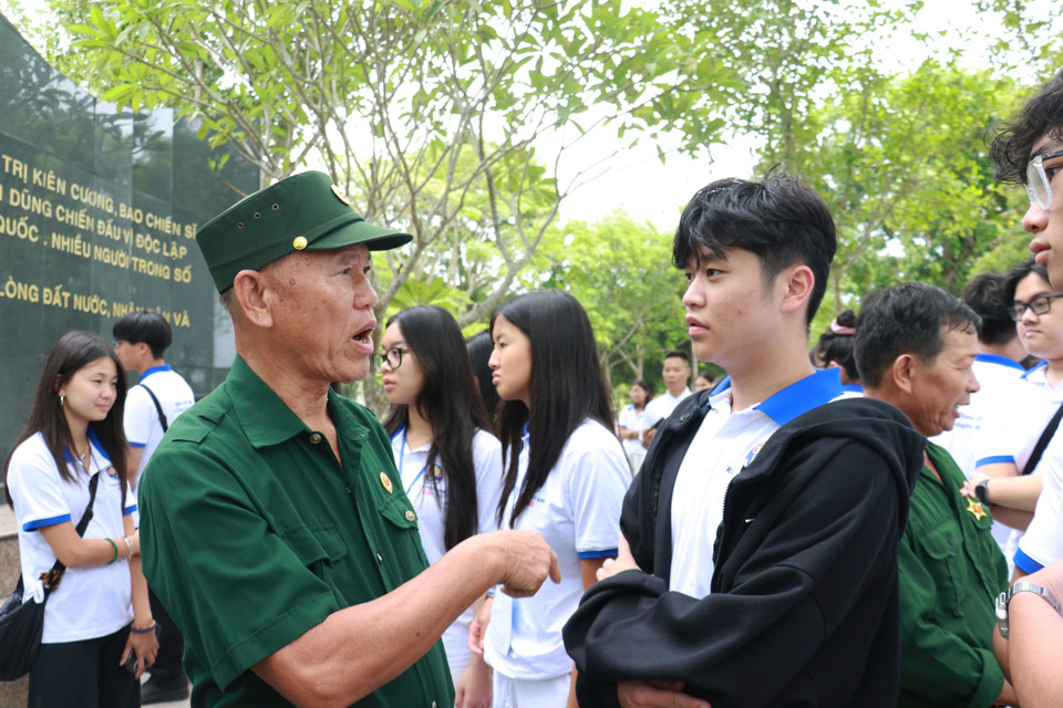 海外青年学生代表团与老兵和冲锋青年队员亲切交流。图自越通社。