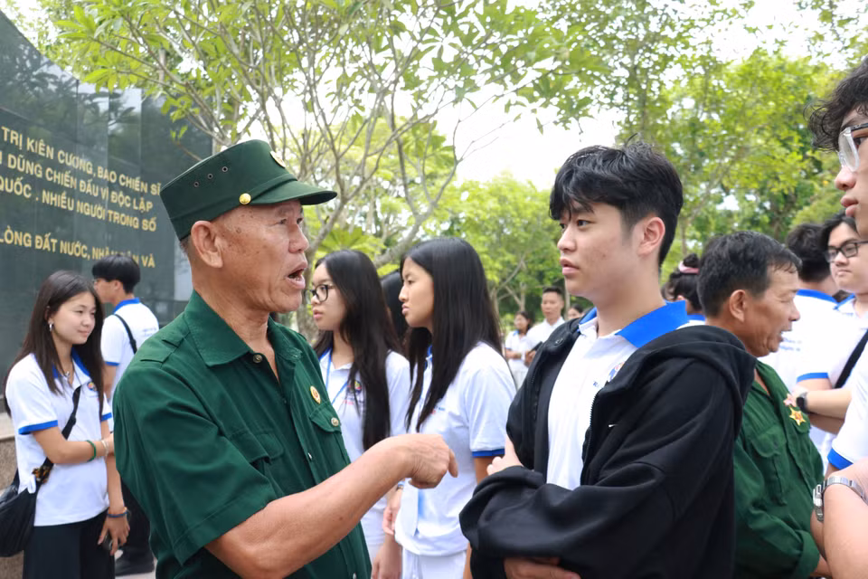 海外青年学生代表团与老兵和冲锋青年队员亲切交流。图自越通社。