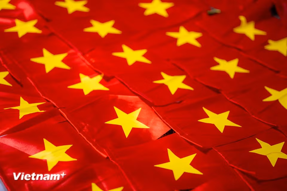 一面面鲜红的金星红旗在工匠的巧手下诞生，为祖国大地增添浓浓的红色喜庆。图自越通社