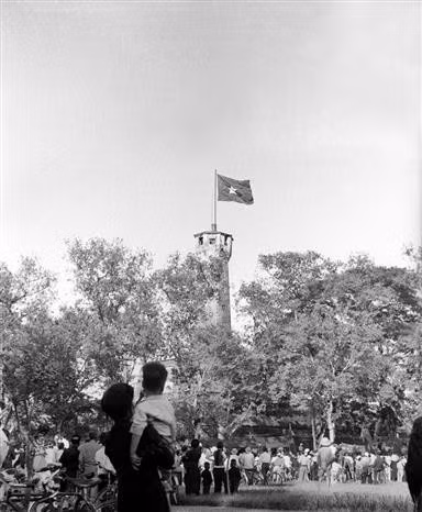 1954年10月10日，首都解放日，人民欢欣鼓舞地望向飘扬在河内旗台上的国旗。图自越通社