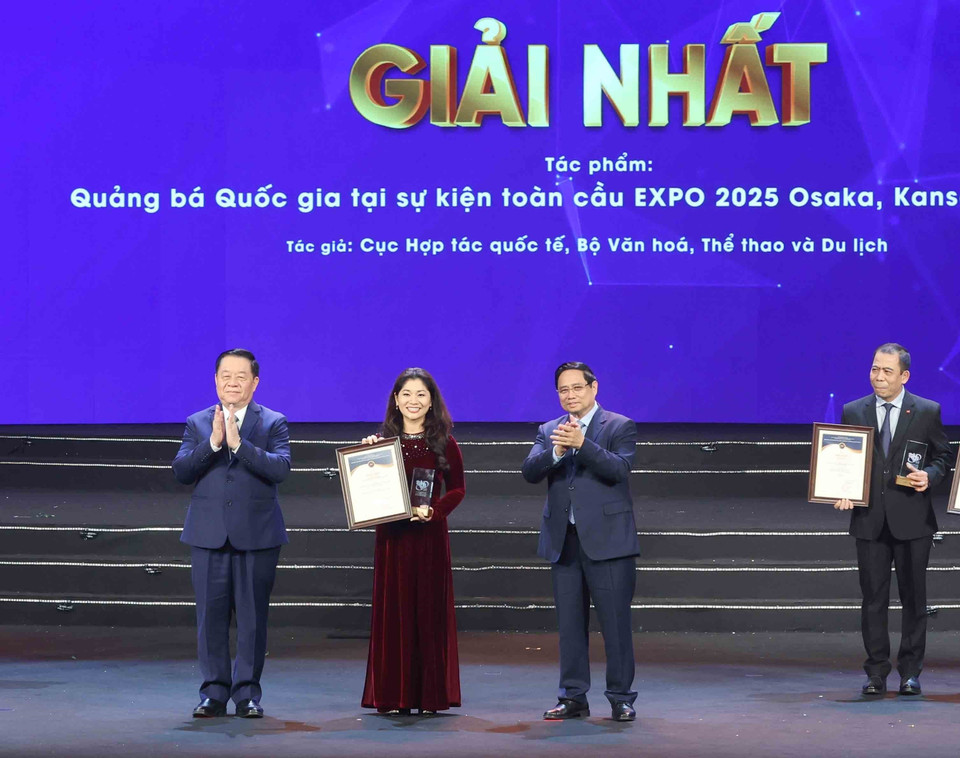 政府总理范明政和越南人民军总政治局主任阮仲义大将为获奖作者及作者组颁发一等奖。图自越通社