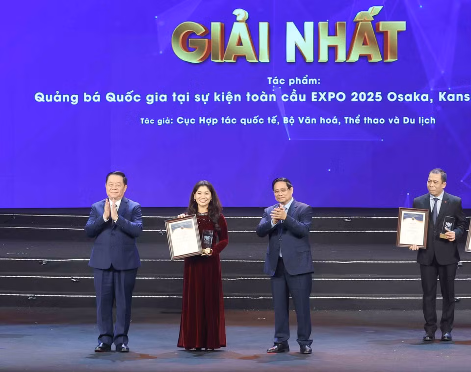 政府总理范明政和越南人民军总政治局主任阮仲义大将为获奖作者及作者组颁发一等奖。图自越通社