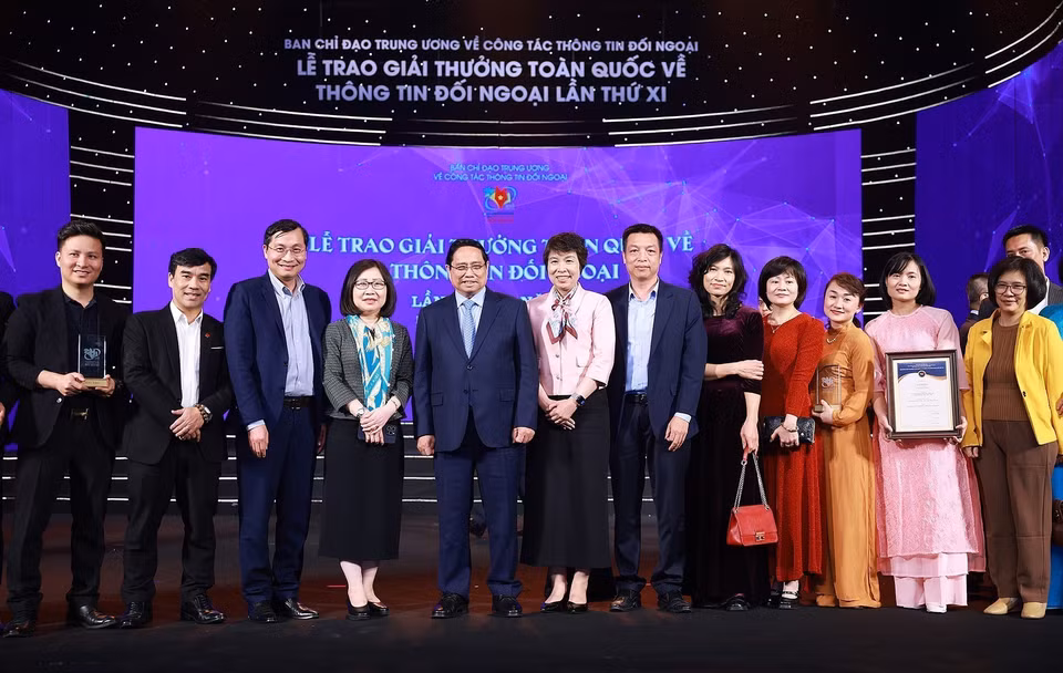 政府总理范明政与荣获第十一届全国对外新闻奖的越南通讯社作者及作者组合影。图自越通社