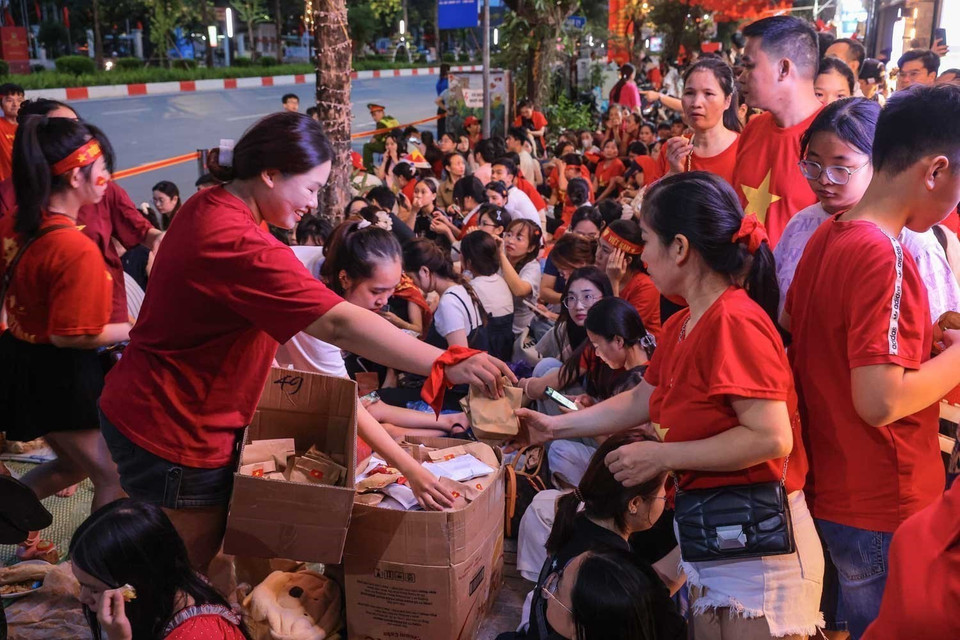 市民自愿互相提供食品，一起等待观看A80盛典。图自越通社