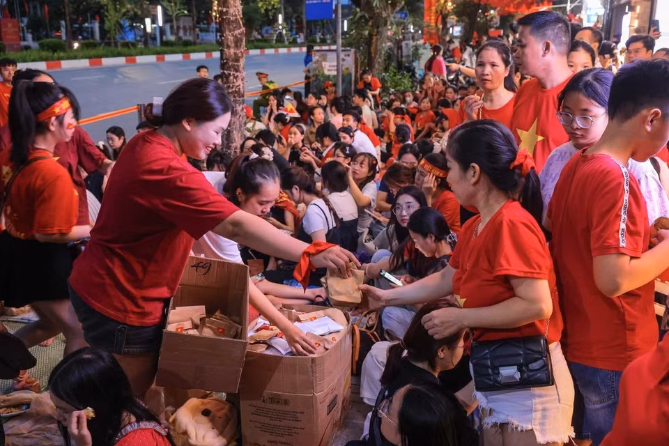 市民自愿互相提供食品，一起等待观看A80盛典。图自越通社