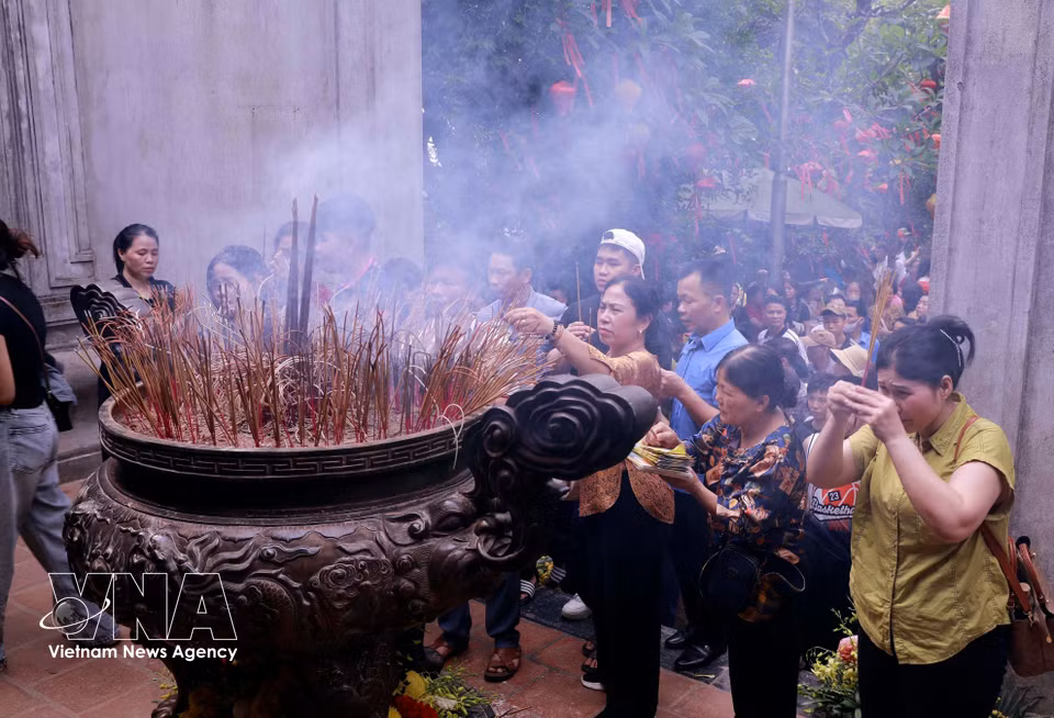 民众和游客在雄王庙怀着诚敬之心焚香祭奠各位雄王。图自越通社