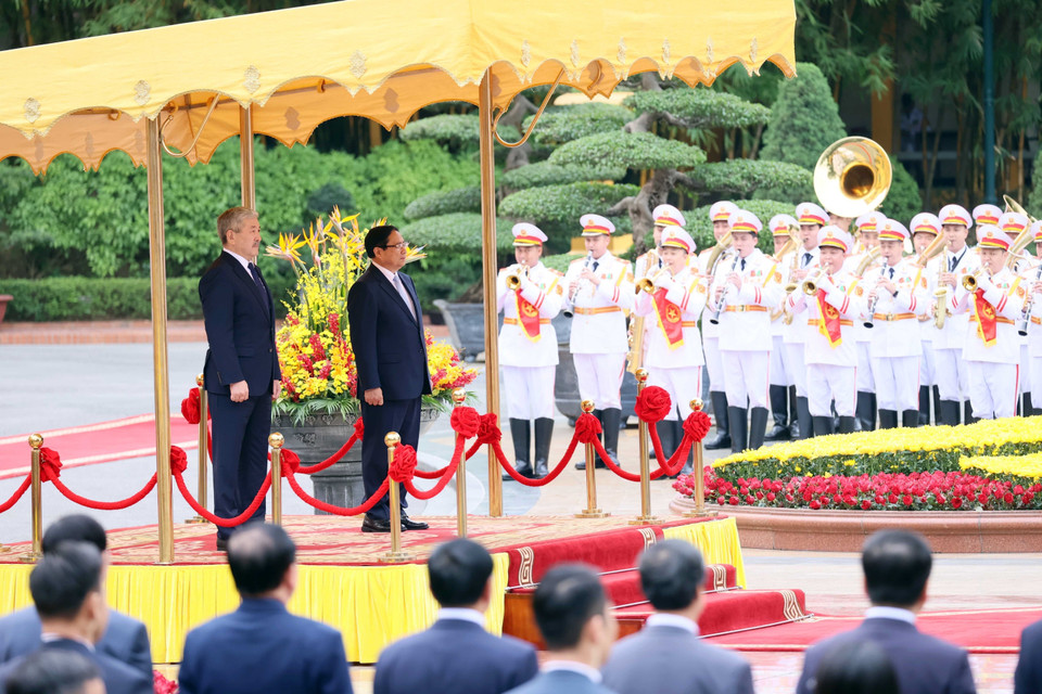 越南政府总理范明政与吉尔吉斯斯坦总理阿德尔别克·卡西马利耶夫聆听军乐团演奏两国国歌。图自越通社