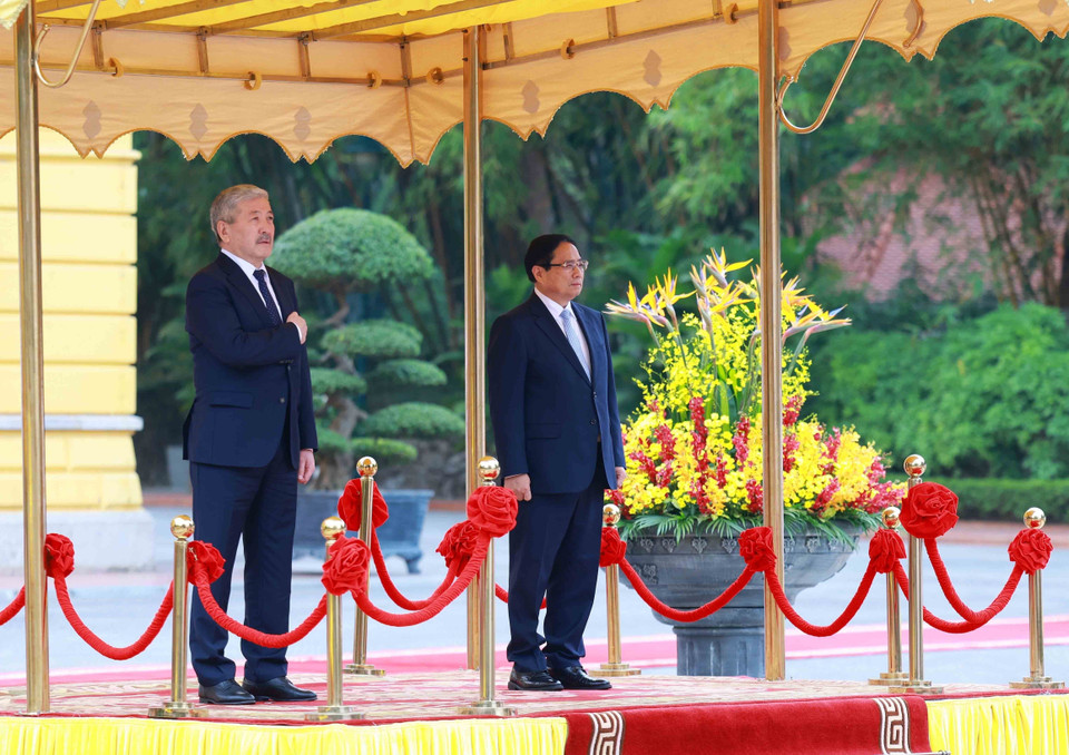 越南政府总理范明政与吉尔吉斯斯坦总理阿德尔别克·卡西马利耶夫聆听军乐团演奏两国国歌。图自越通社