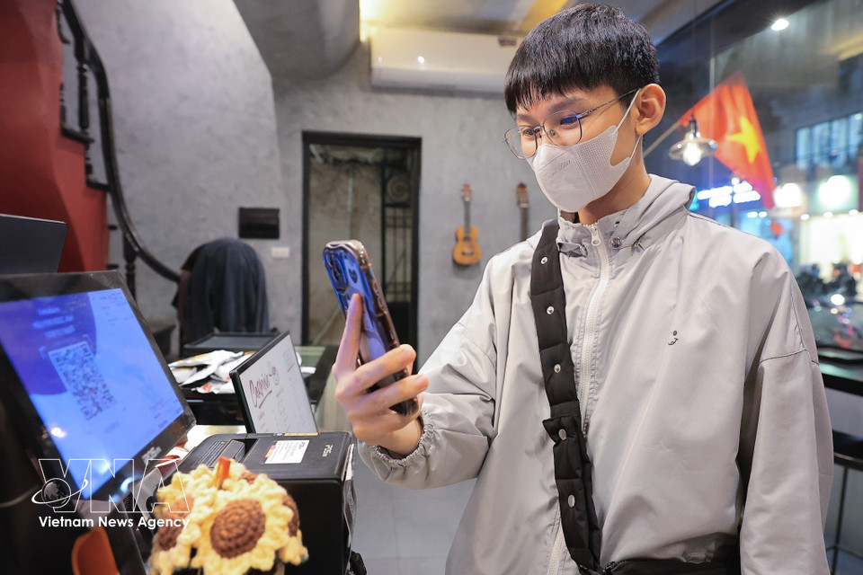 只需一部智能手机，民众便可在几秒内轻松完成支付交易。图自越通社