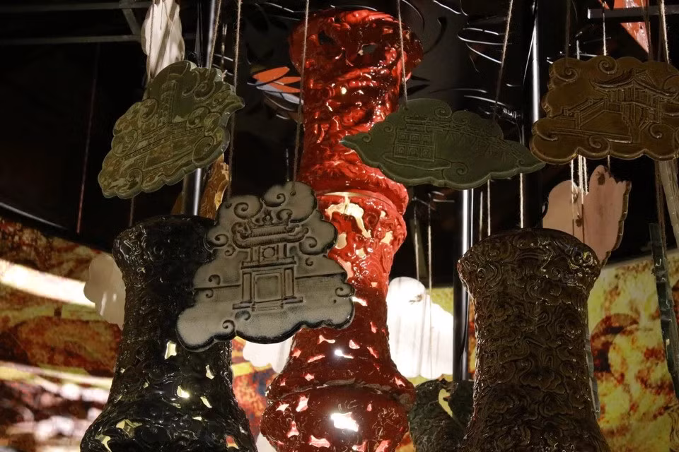 这是一盏大型灯饰，装饰着丰富的古典纹样，刻画了铸造、锻造、银饰制作、刺绣、铜铸、纸扎、印章雕刻等传统手工艺的形象。图自Vietnam+