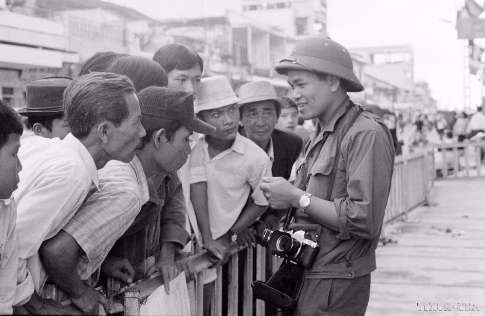 越南通讯社记者许检与西贡民众接触，进行报道和拍摄有关1975年历史性的胡志明战役取得胜利、彻底解放南方、统一国家。图自越通社