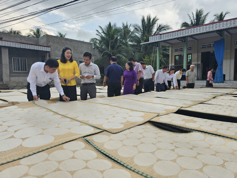 游客亲身体验山督米饼的晾晒工序。图自越通社