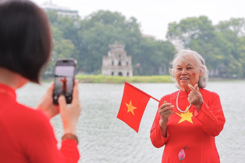 老年人也融入节日氛围,在还剑湖边定格美好回忆。图自越通社