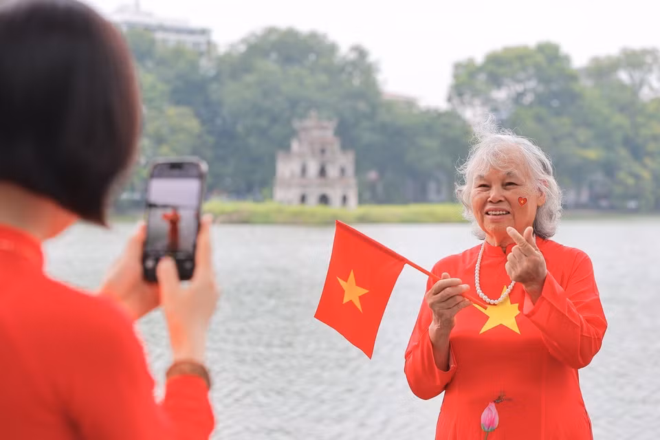 老年人也融入节日氛围，在还剑湖边定格美好回忆。图自越通社