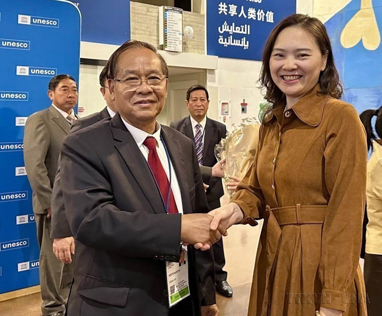 越南代表团向老挝代表团祝贺，庆祝联合国教科文组织正式批准越老两国世界自然遗产边界调整（巴黎，2025年7月13日）。图自越通社