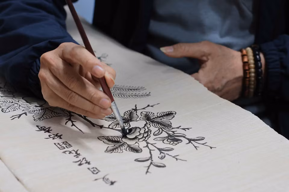 在绘制东湖画时，艺人们常使用毛笔蘸取墨水，在楮纸上细腻作画。图自越通社