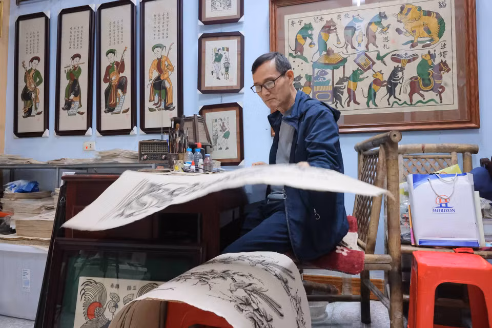 优秀工匠阮有果至今仍每日勤勉工作，以画笔和纸张传承着传统民间绘画技艺。图自越通社