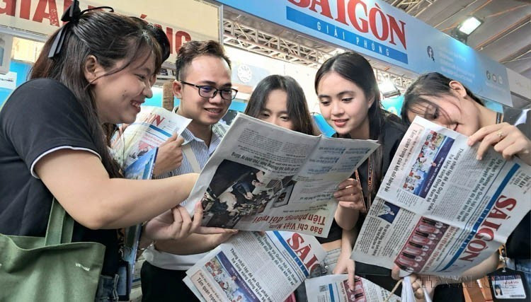 2024年全国报刊展上,读者在胡志明市兴致勃勃地了解一份“49岁”的党报。图自越通社