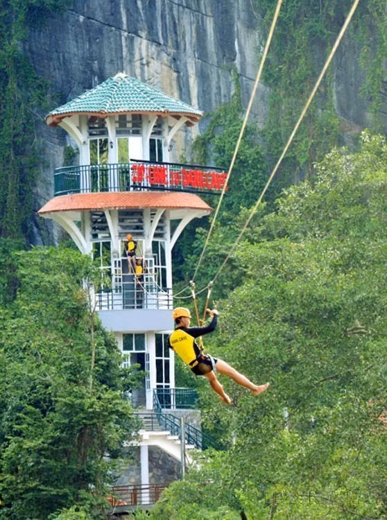 游客在峰衙－几榜国家公园的杵河-暗洞旅游线路体验空中滑索活动。图自越通社