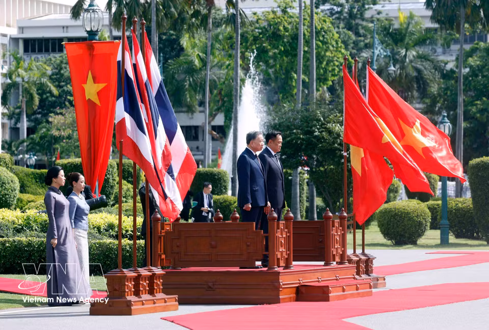 越共中央总书记、国家主席苏林与泰国总理阿努廷·查恩维拉库尔在检阅台上，聆听军乐队奏两国国歌。图自越通社