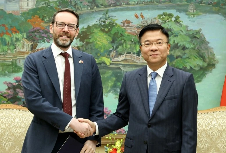越南政府副总理黎成龙与英国驻越南特命全权大使伊恩·弗鲁亲切握手。图自越通社