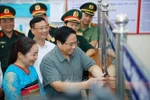 范明政总理视察清化省山区边境乡钵默行政审批工作。图自越通社