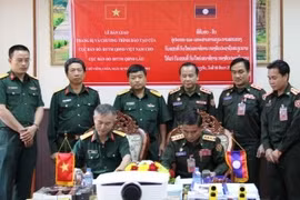 老挝人民军总参谋部国家地图局局长Thonchan Vannasi大校同越南人民军总参谋部地图处下属军事地形业务培训中心经理黄文武大校签署移交书