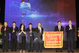 阮善仁同志代表党和国家向通讯社电视频道赠送“准确、及时、随时随地和充满人性”的横幅题（图片来源：越通社）