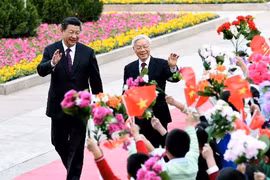 越共中央总书记阮富仲今年4月正式访华期间与中共中央总书记、国家主席习近平同少年儿童们亲切挥手（示意图、图片来源：laodong.com.vn）