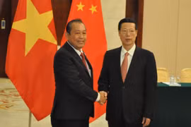 越共中央政治局委员、政府常务副总理张和平（左）会见中共中央政治局常委、国务院副总理张高丽。（图片来源：越通社）