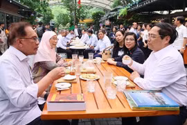 范明政与马来西亚总理安瓦尔·易卜拉欣参观图书街 品尝越南咖啡