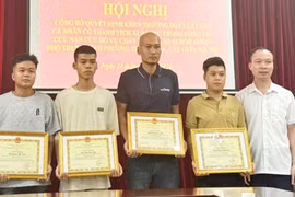 四名青年因勇敢救助火灾中受困人员而获得纸桥郡人民委员会的奖状。图自越通社