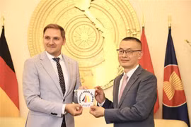 帕特里克·达勒曼向武光明赠送“一同扬帆出海”符号。图自越通社