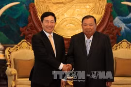 越南政府副总理兼外交部长范平明​​与老挝人民革命党中央总书记、国家主席本扬·沃拉吉会见合影（图片来源：越通社）