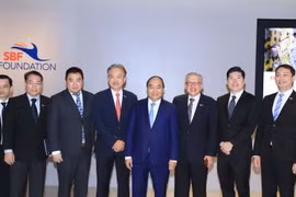 政府总理阮春福与新加坡一流企业集团领导代表合影。（图片来源：越通社）
