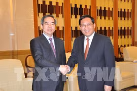 越共中央政治局委员、中央书记处书记、中央经济部部长阮文平会见中共中央政治局委员、上海市委书记李强。(图片来源：越通社）
