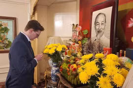 越南历史政治研究员、英国共产党党员基里尔·惠特克在越南驻英国大使馆向胡志明主席进香。图自越通社