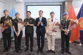 越南常驻联合国代表团团长邓黄江大使向联合国维和局的干部送花。图自越通社
