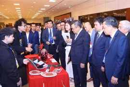 河内市委副书记、市人民委员会主席阮士青和代表们参观服务智慧城市建设事业产品和服务的展位。图自越通社