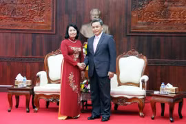 越南祖国阵线中央委员会副主席裴氏青与老挝建国阵线中央委员会副主席占塔翁亲切握手（图片来源：越南人民报）