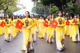 越南女性身穿奥黛跳民间舞蹈活动。图自越共电子报