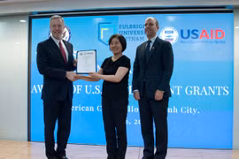 美国驻越大使（左）向颁发越南富布赖特大学校长（左二）颁发援助决定。（图片来源：越通社） 