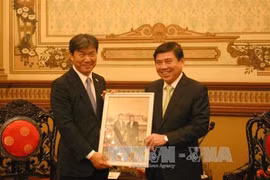 胡志明市人民委员会主席阮成峰向日本国自治体国际化协会（CLAIR）理事长冈书保送纪念品（图片来源：越通社）