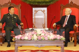 越共中央总书记阮富仲（右）6月18日在河内会见中共中央政治局委员、中央军委副主席范长龙上将（左）。