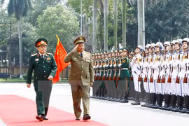 越南国防部部长吴春历大将和古巴命武装力量部部长莱奥波尔多•辛特拉•弗里亚斯上将检阅仪仗队。（图片来源：越通社）